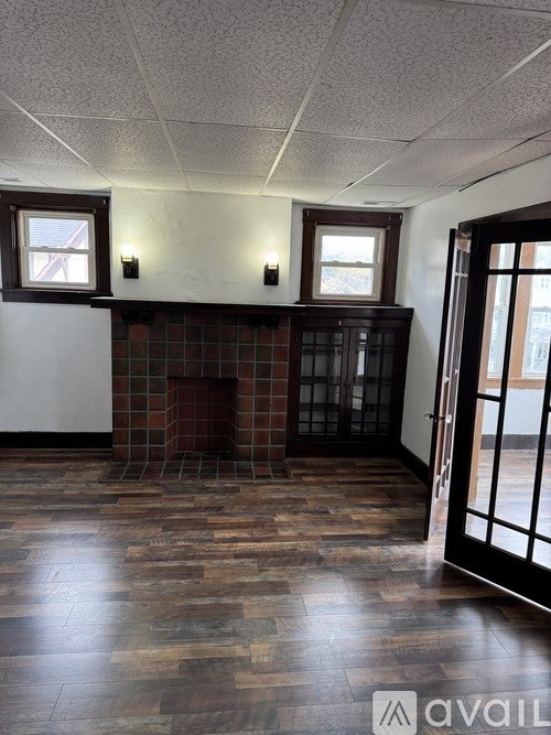 A room with a fireplace and wood flooring.