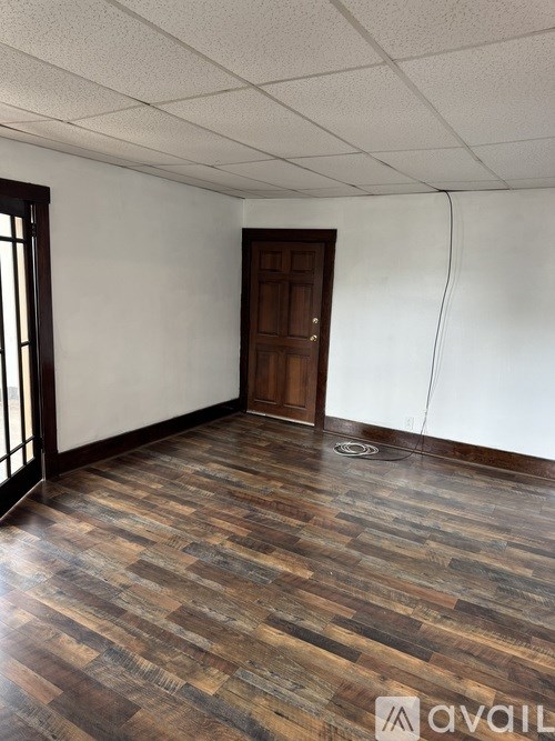 A room with wooden flooring and a door.