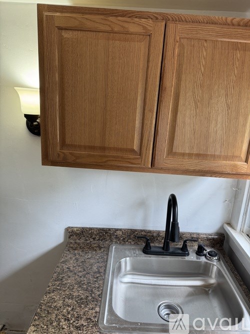 A kitchen with wooden cabinets and a granite countertop.