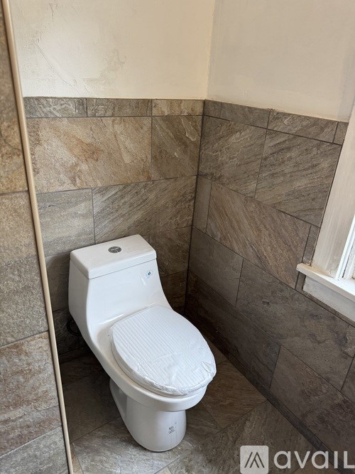 A white toilet in a bathroom with tiled walls.