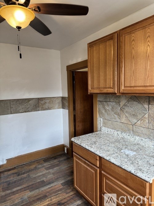 A kitchen with wooden cabinets and a ceiling fan.