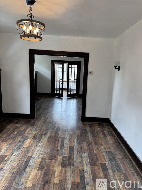 A room with wooden floors and a chandelier.