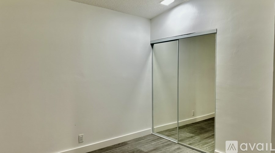 A room with a white wall and a glass door.