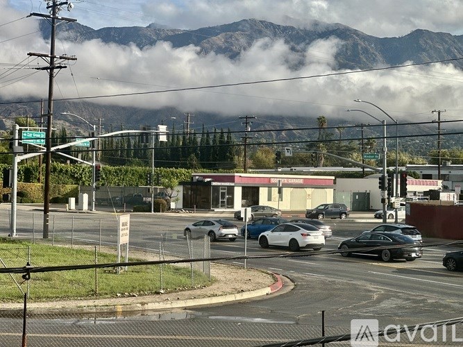 A city street with cars and a mountain in the background.