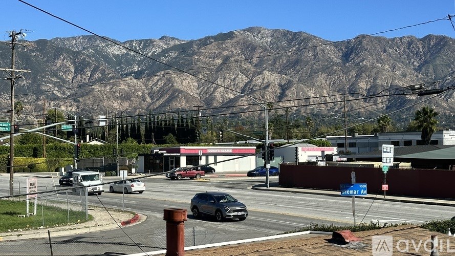 A street view with cars and a mountain in the background.
