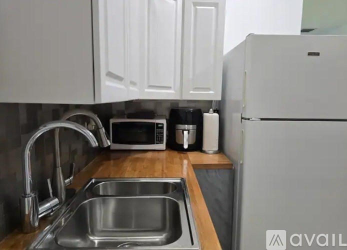 A kitchen with a sink, microwave, and refrigerator.