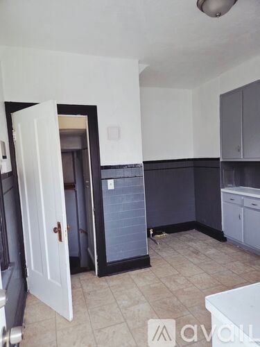 A kitchen with a white door and a white cabinet.