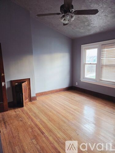 A room with wooden floors and a ceiling fan.