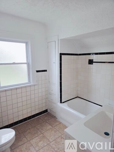 A bathroom with a toilet, sink, and bathtub.