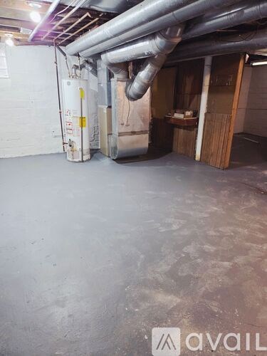 A room with a white wall and a white floor with a pipe running along the wall.