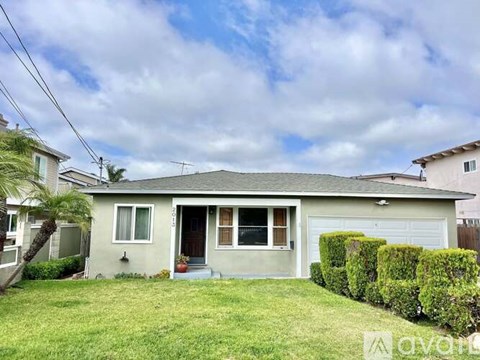 A house with a grey roof and a white garage door.