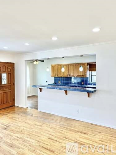 A kitchen with wooden cabinets and a blue tile backsplash.