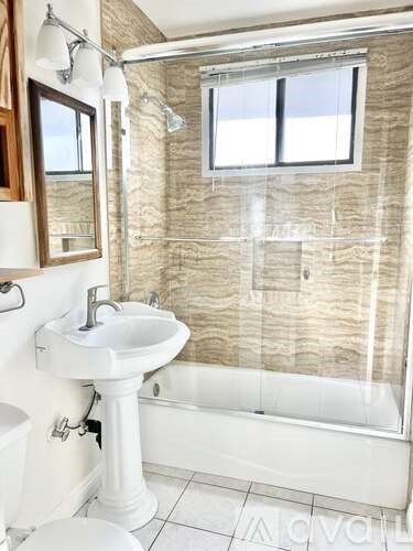 A bathroom with a white pedestal sink and a white toilet.