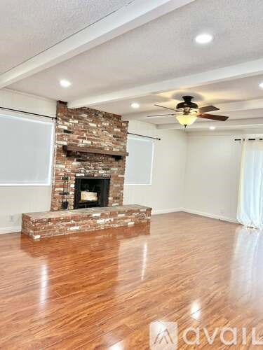 A room with a fireplace and a ceiling fan.
