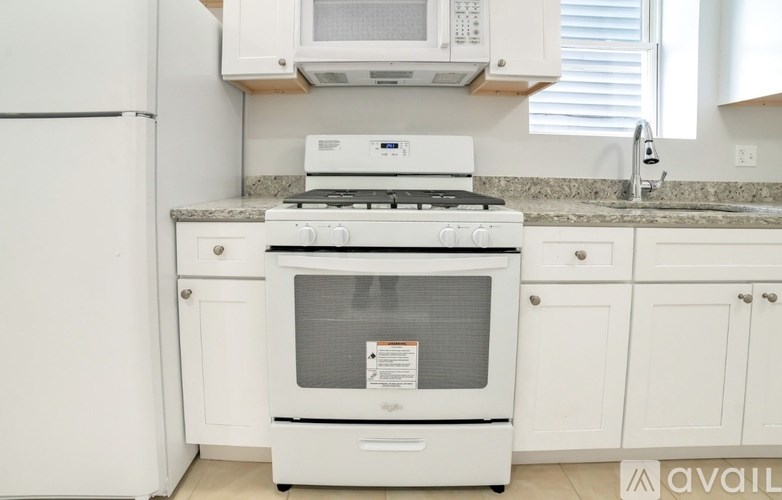 A white oven with a stove top sits in a kitchen.