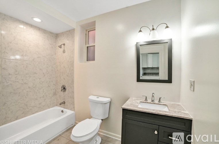 A bathroom with a white toilet, sink, and bathtub.