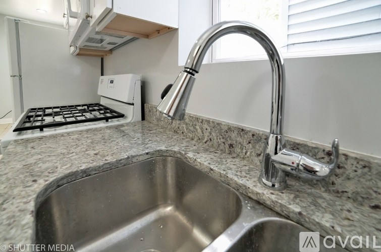 A kitchen with a stove, sink, and faucet.