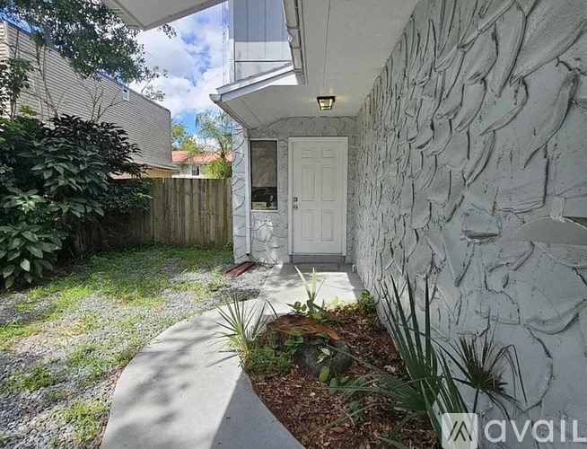 A white house with a stone wall and a white door.