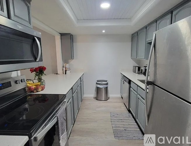 A kitchen with a stove, microwave, and refrigerator.