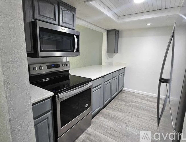 A kitchen with a black stove top oven and microwave.