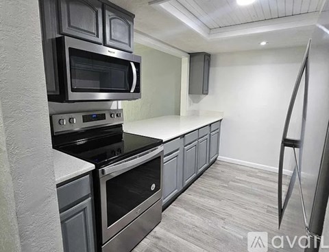A kitchen with a black stove top oven and microwave.