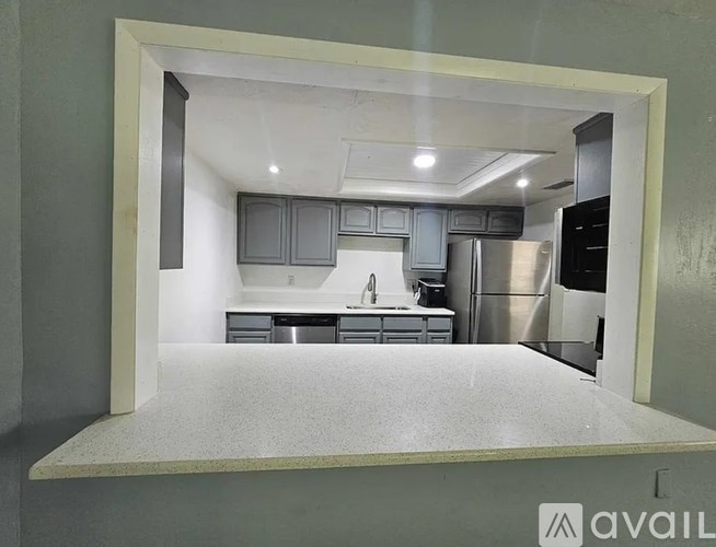 A kitchen with a white countertop and stainless steel appliances.