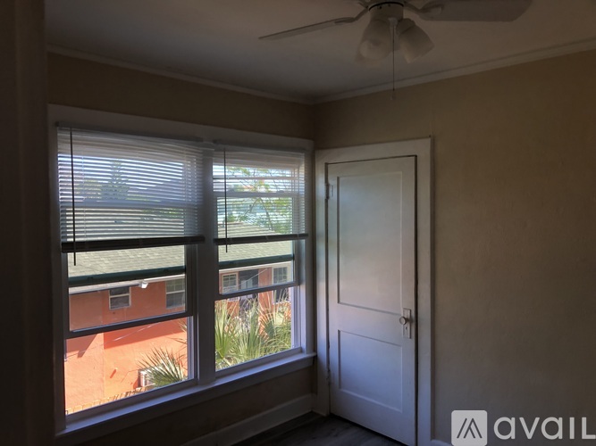 A room with a window overlooking a red building.
