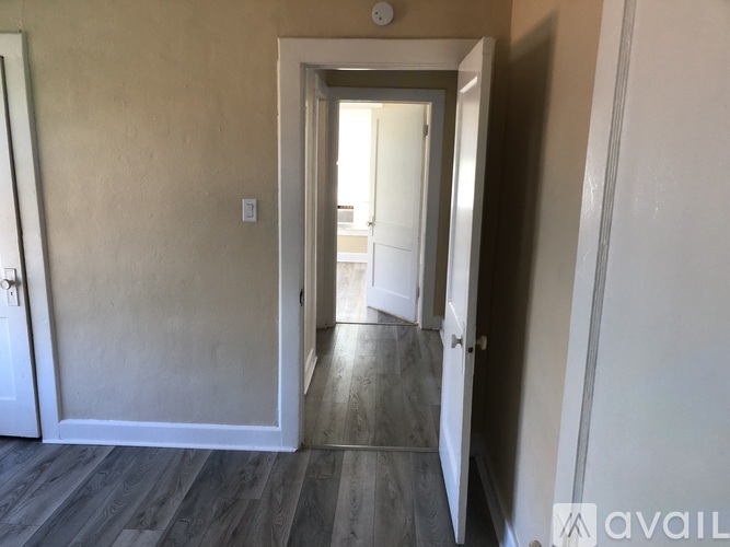 A hallway with a door on the left and a door on the right.