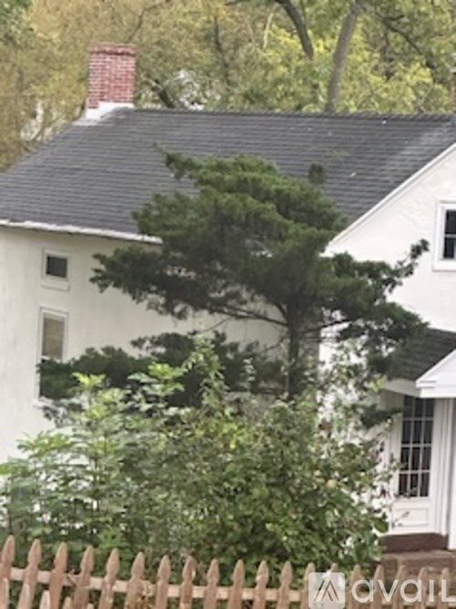 A white house with a brown fence in front of it.