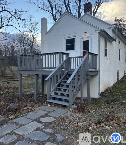 A white house with a grey staircase leading to the front door.