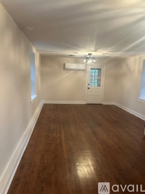 A room with wooden flooring and a white door.