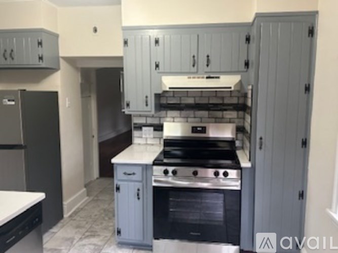A kitchen with a stove top oven and a refrigerator.