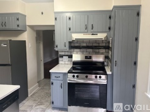 A kitchen with a stove top oven and a refrigerator.