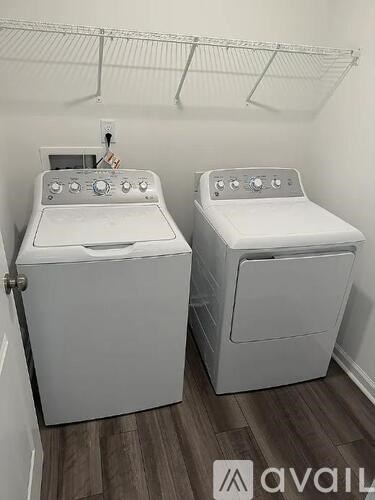 Two white front loading washing machines in a laundry room.