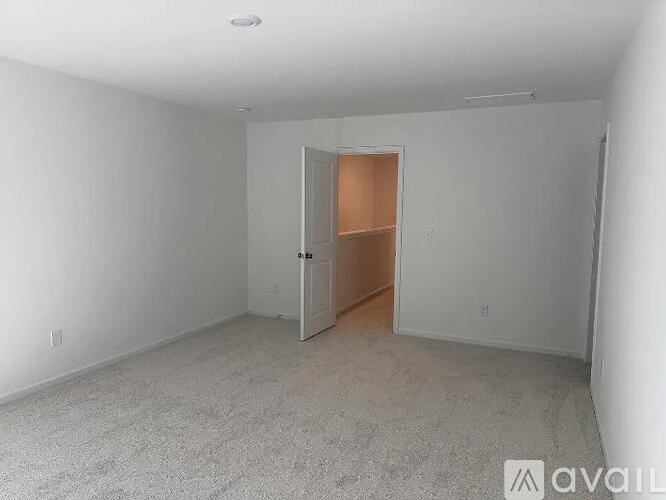 A room with a carpeted floor and a door leading to another room.