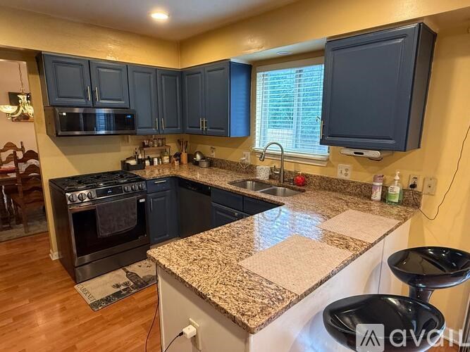 A kitchen with granite countertops and a black oven.