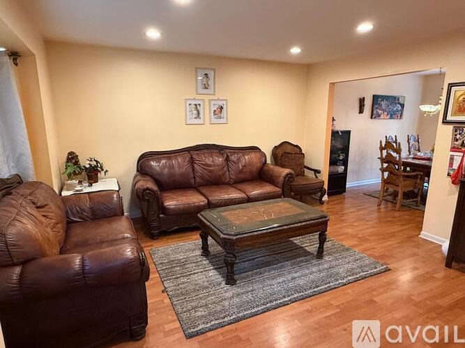 A living room with brown leather furniture and a coffee table.
