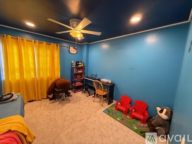 A room with a blue wall and a ceiling fan.