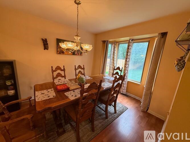 A dining room with a wooden table and chairs.