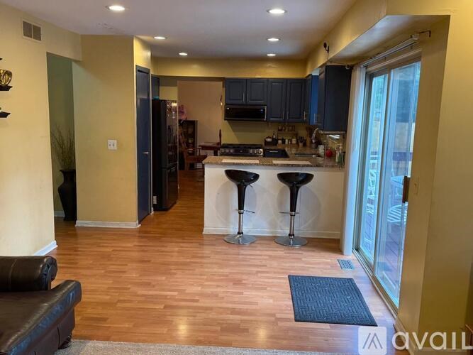 A kitchen with a bar stool in front of it.