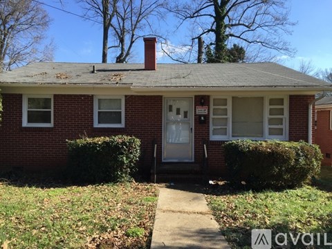 A red brick house with a white door and windows.
