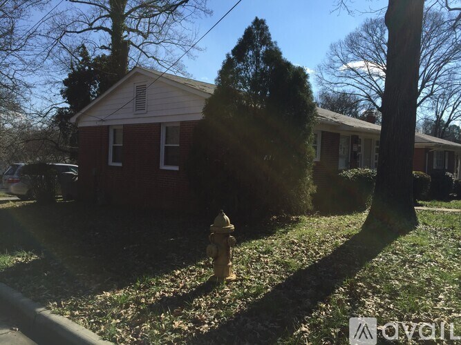 A fire hydrant is in the foreground of a residential area with houses and trees.