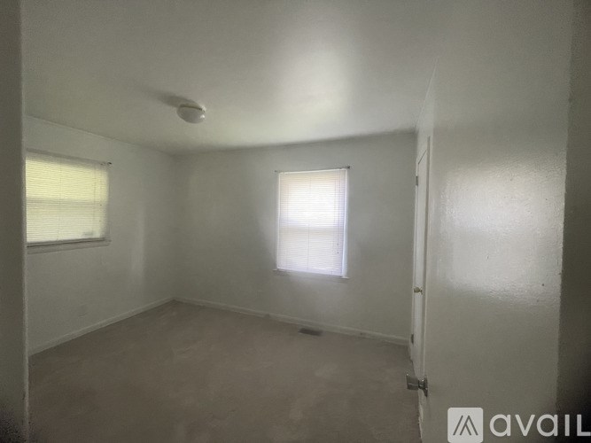 A small, empty room with a window and a door.