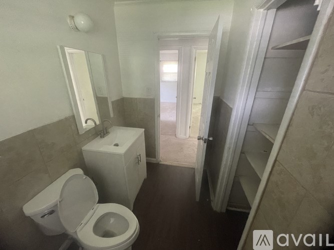 A bathroom with a toilet, sink, and a staircase.