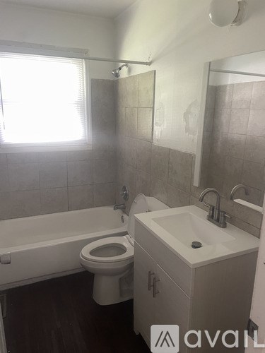 A white toilet sits in a bathroom next to a sink.