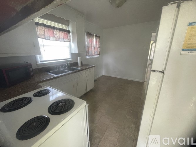 A kitchen with a white stove and a white fridge.