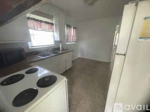 A kitchen with a white stove and a white fridge.