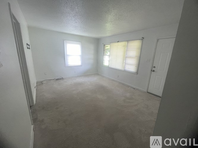 A room with a window and a door is available for rent.