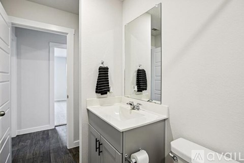 A bathroom with a white sink and a mirror.