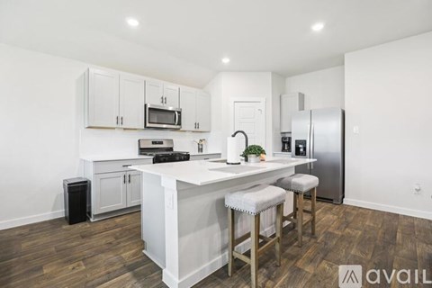 A kitchen with white cabinets and a wooden floor.